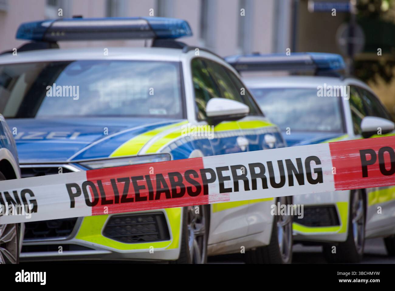 (Fotomontaggio) immagine simbolica di un'operazione di polizia: Cordone di polizia di fronte a un veicolo di emergenza Foto Stock (Fotomontaggio) immagine simbolica di un'operazione di polizia: Cordone di polizia di fronte a un veicolo di emergenza Foto Stock