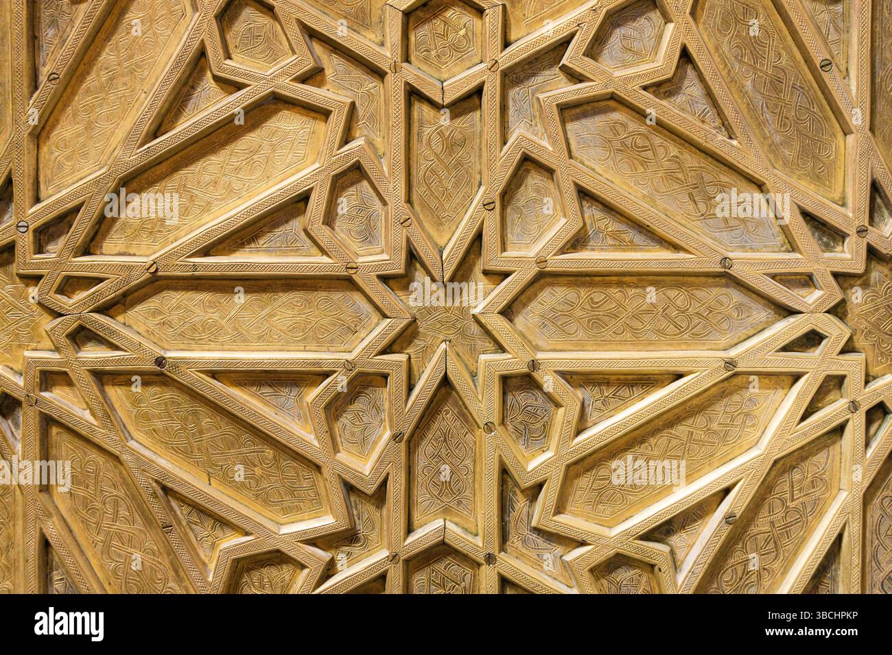 Motivo arabesco metallizzato dorato. Geometria ornamentale islamica. Sfondo decorativo con superficie dorata. Tradizionale design simmetrico mediorientale. Foto Stock