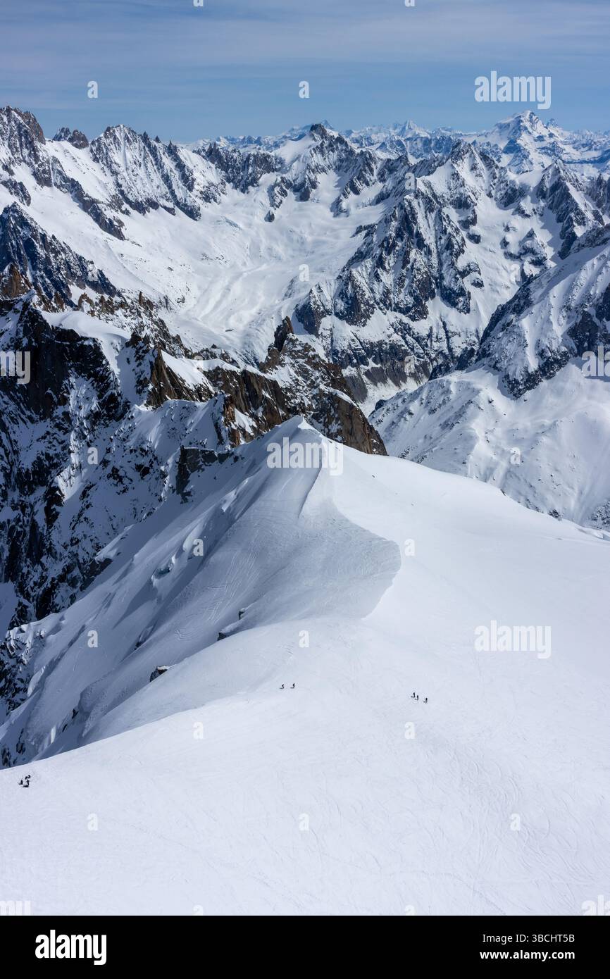 Scialpinisti su una splendida cresta vicino a Aigulle du Midi nel massiccio del Monte bianco nelle alpi francesi sopra Chamonix, con uno scenario montano spettacolare. Foto Stock