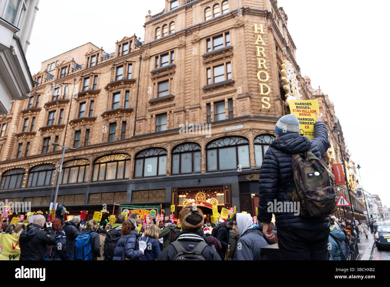I manifestanti si radunano fuori dai grandi magazzini Harrods a Londra mentre i lavoratori Harrods rappresentati dalla United Voices of the World (UVW) union sono in sciopero Foto Stock