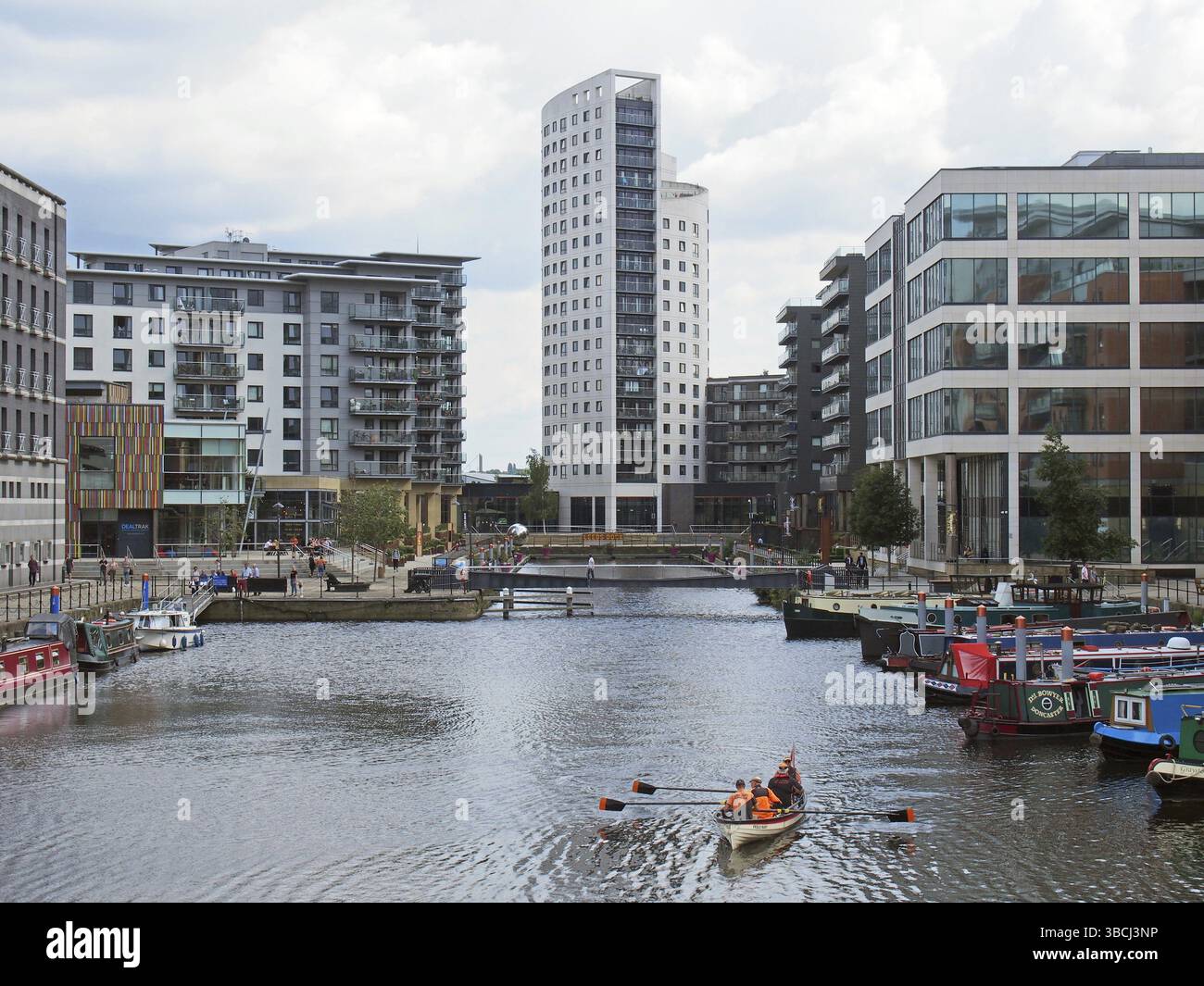 Leeds, West yorkshire, regno unito, 16 luglio 2019: leeds ormeggia dalle porte chiuse con case galleggianti ed edifici con un equipaggio di barche a remi sull'acqua Foto Stock