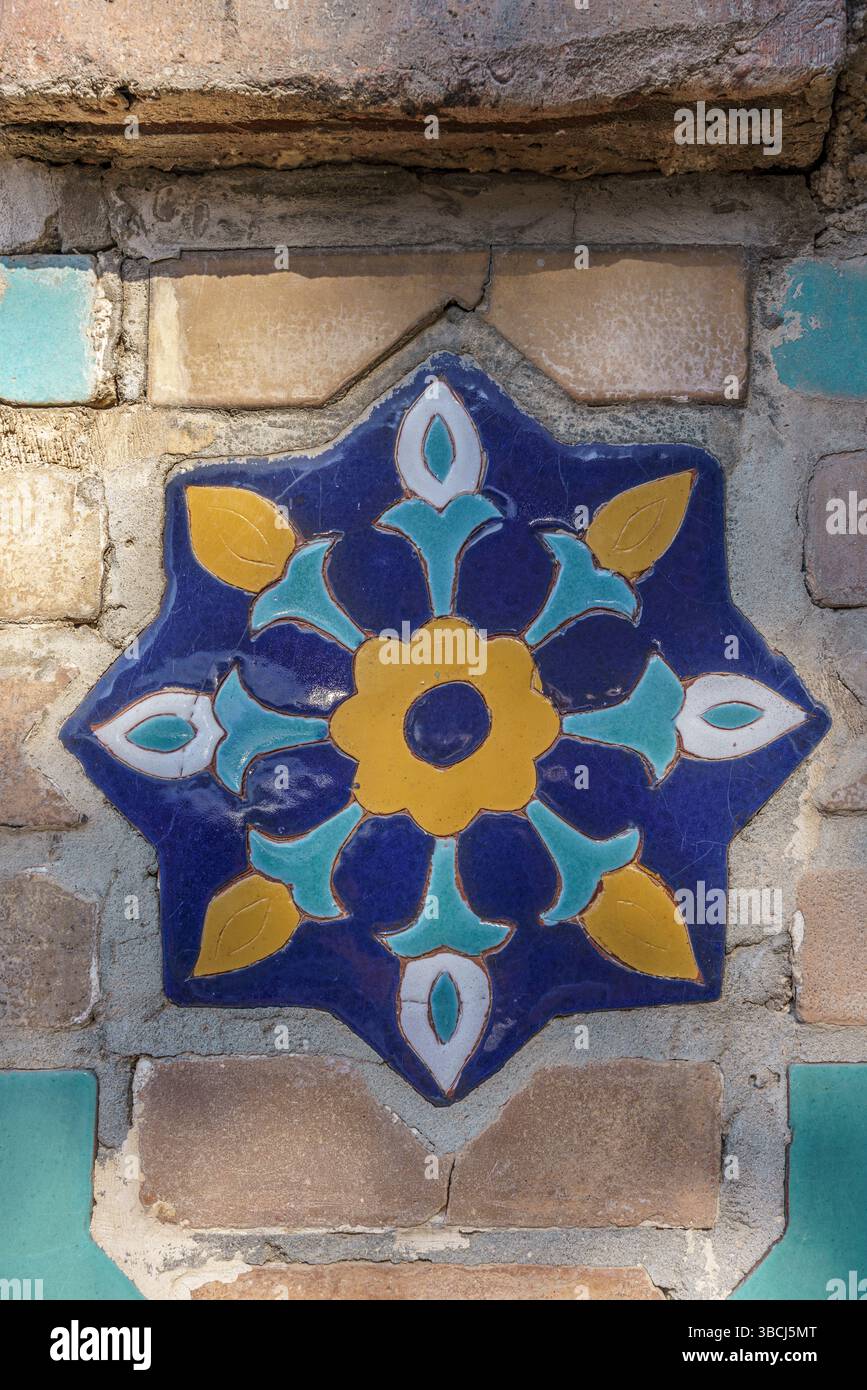 Un mosaico piastrellato a forma di stella illumina la facciata del Mausoleo Gur e Amir a Samarcanda, Uzbekistan, con audaci colori classici timuridi. Foto Stock