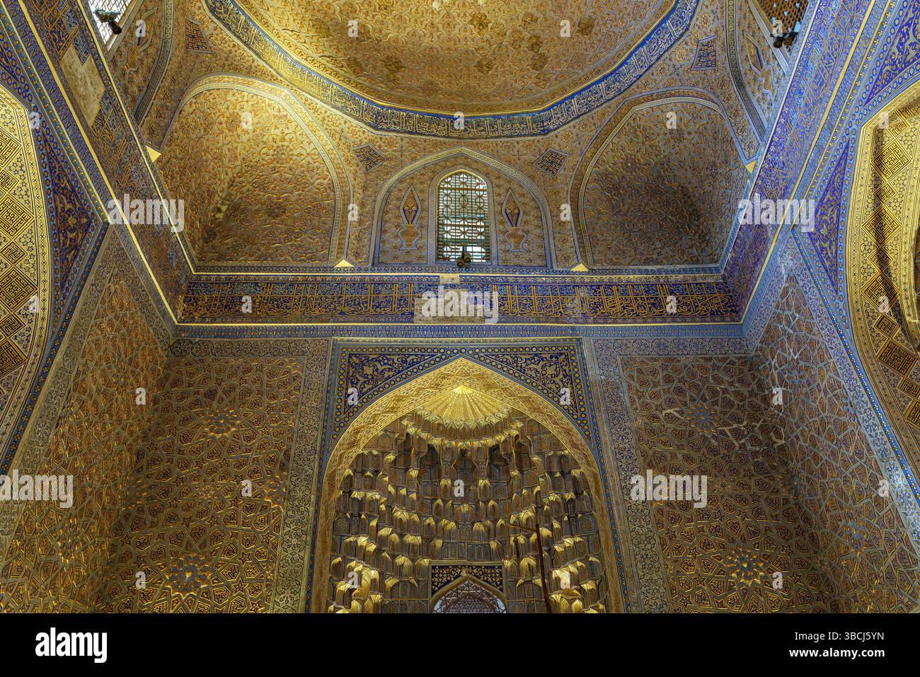 Le luci dorate rivelano cupole svettanti all'interno del Mausoleo di Gur e Amir a Samarcanda, Uzbekistan, mostrando splendidi dettagli architettonici islamici. Foto Stock