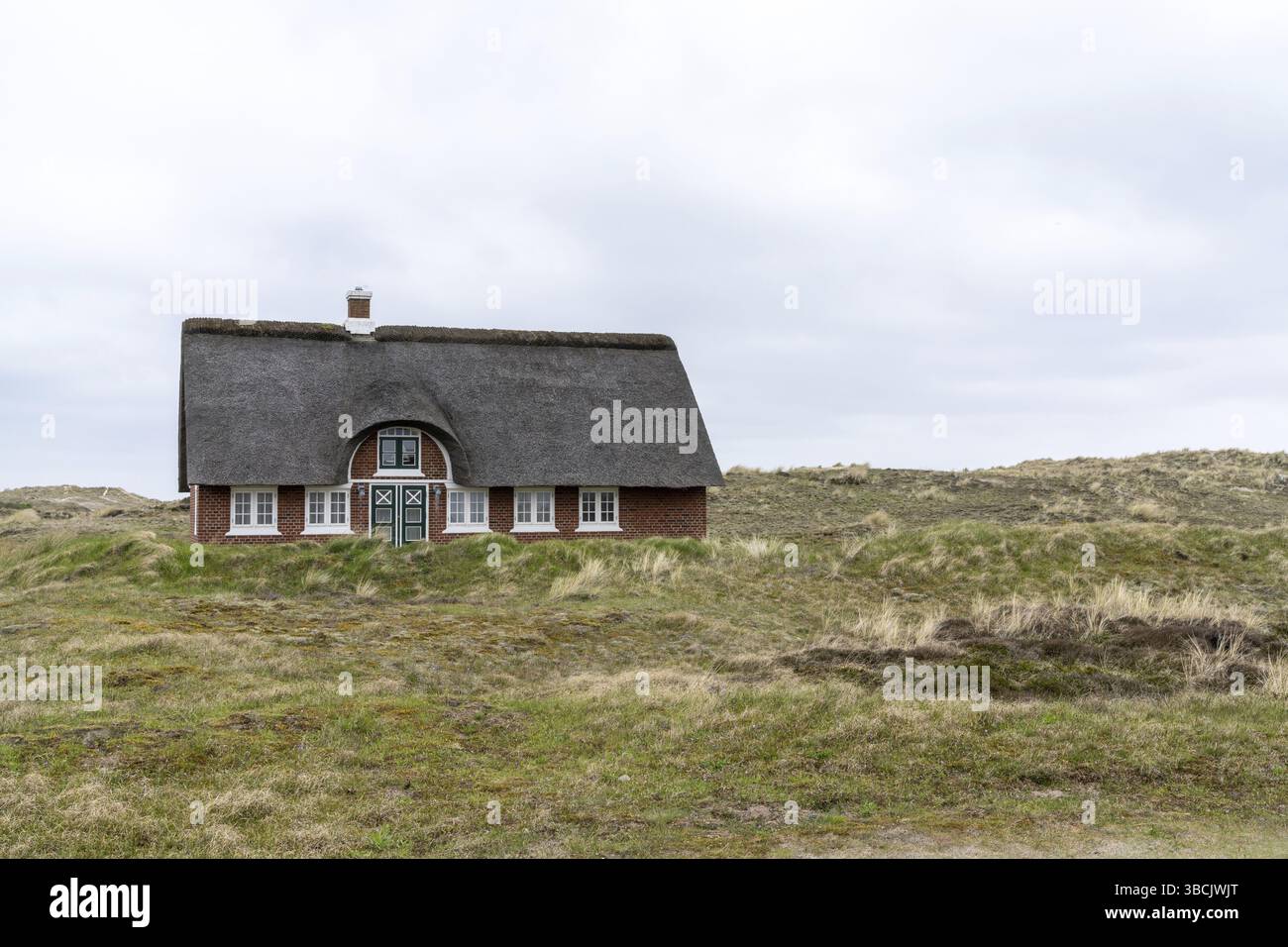 Sonderho, Danimarca - 29 maggio 2021: Tradizionale casa danese con tetto di paglia canna in un paesaggio di dune di sabbia costiera Foto Stock