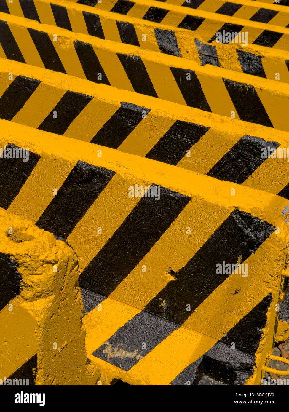 Blocchi di cemento neri e gialli su una strada e di fronte a un cantiere - foto di scorta Foto Stock