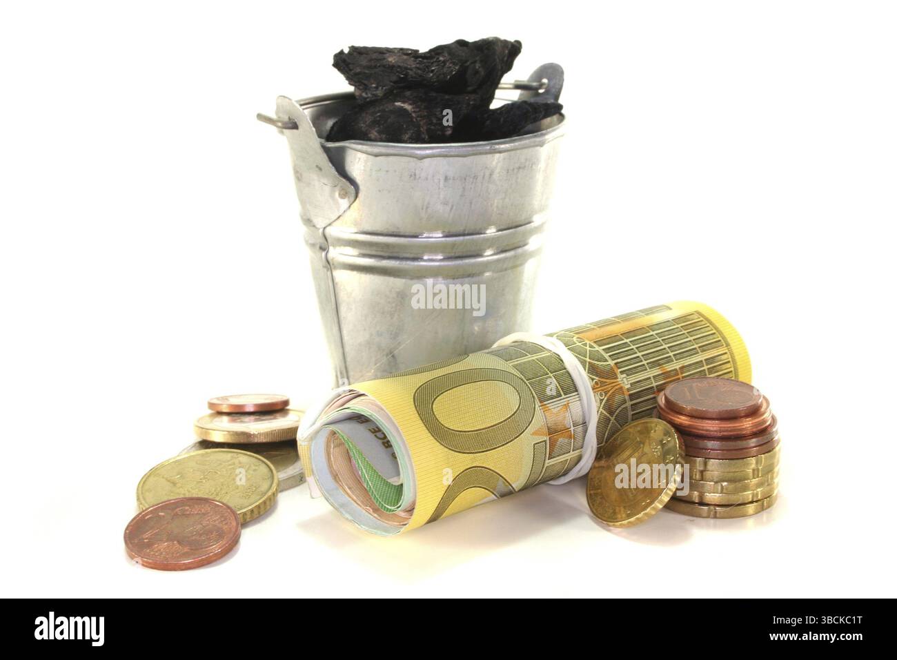 Secchio con banconote in euro e carbone davanti a sfondo bianco Foto Stock