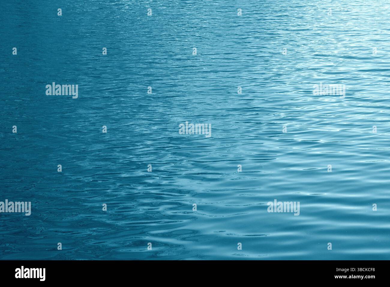 Fondo di acqua di lago con piccole onde di tinta blu-verdastro. Foto Stock