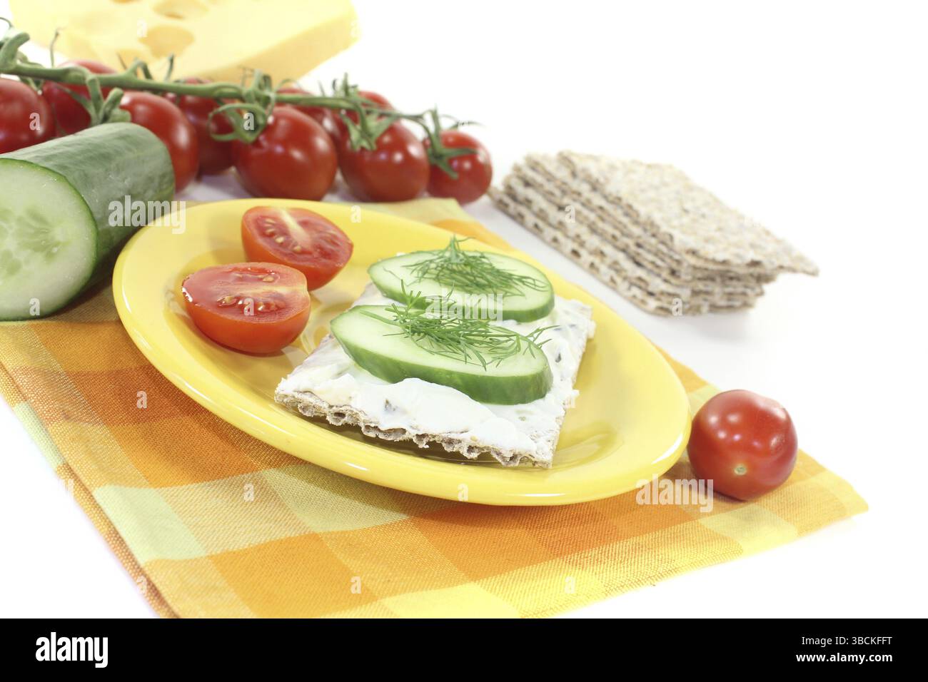 Pane croccante con formaggio spalmabile e cetriolo su sfondo di colore chiaro Foto Stock
