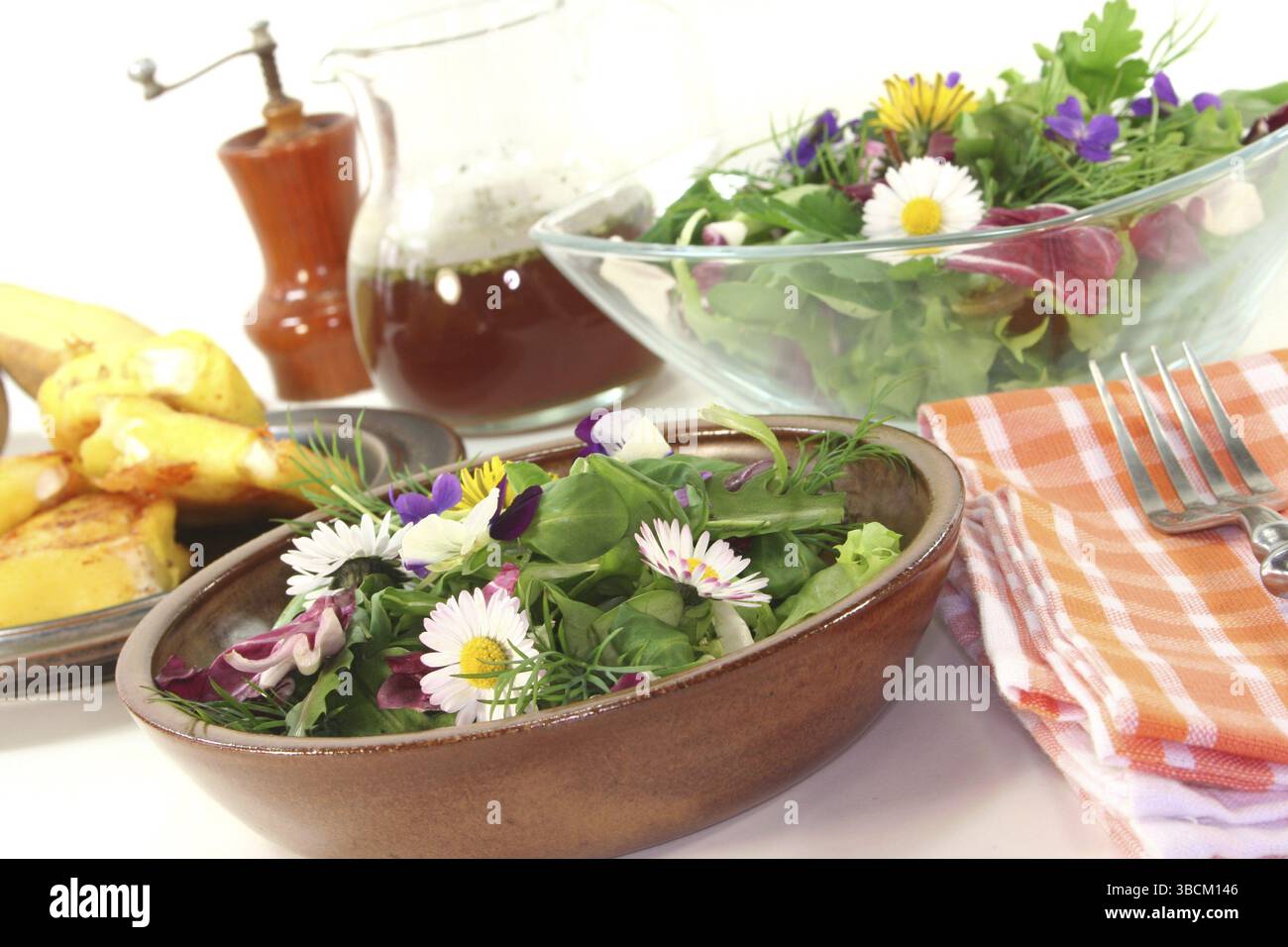 Insalata di erbe selvatiche con formaggio di capra ricoperto di patate su sfondo bianco Foto Stock