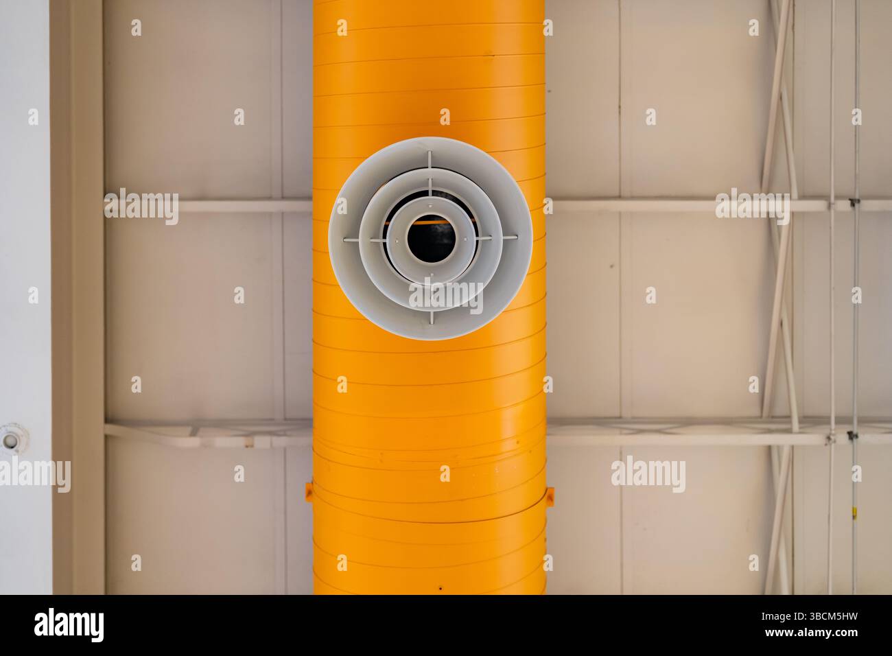 HVAC per interni, sistemi meccanici, condotto arancione, tubi di ventilazione, con diffusore bianco, appeso al soffitto di un grande spazio aperto. Foto Stock