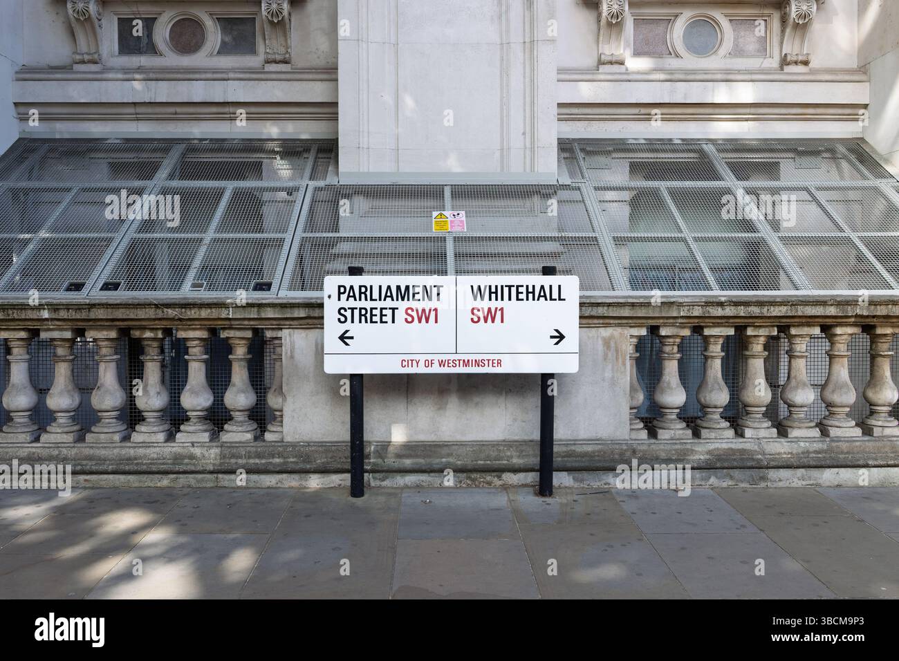 Cartelli stradali bianchi che indicano le indicazioni per Parliament Street e Whitehall a Westminster, Londra. Foto Stock