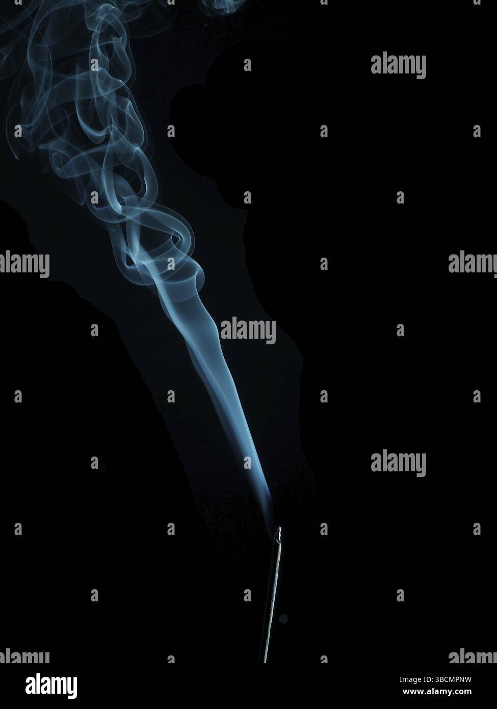 Incenso con fumo blu su sfondo scuro con spazio per il testo Foto Stock