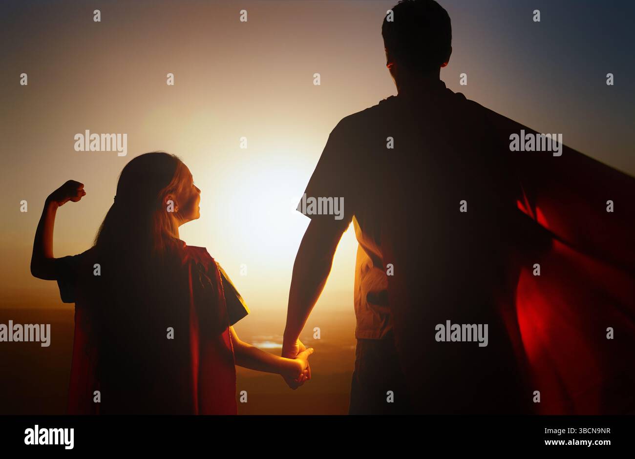 Famiglia felice amorevole. Padre e sua figlia giocano all'aperto. Daddy e la sua bambina in costumi di un Supereroe. Foto Stock