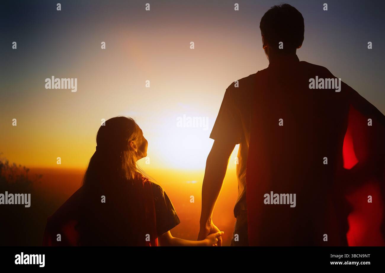 Famiglia felice amorevole. Padre e sua figlia giocano all'aperto. Daddy e la sua bambina in costumi di un Supereroe. Foto Stock