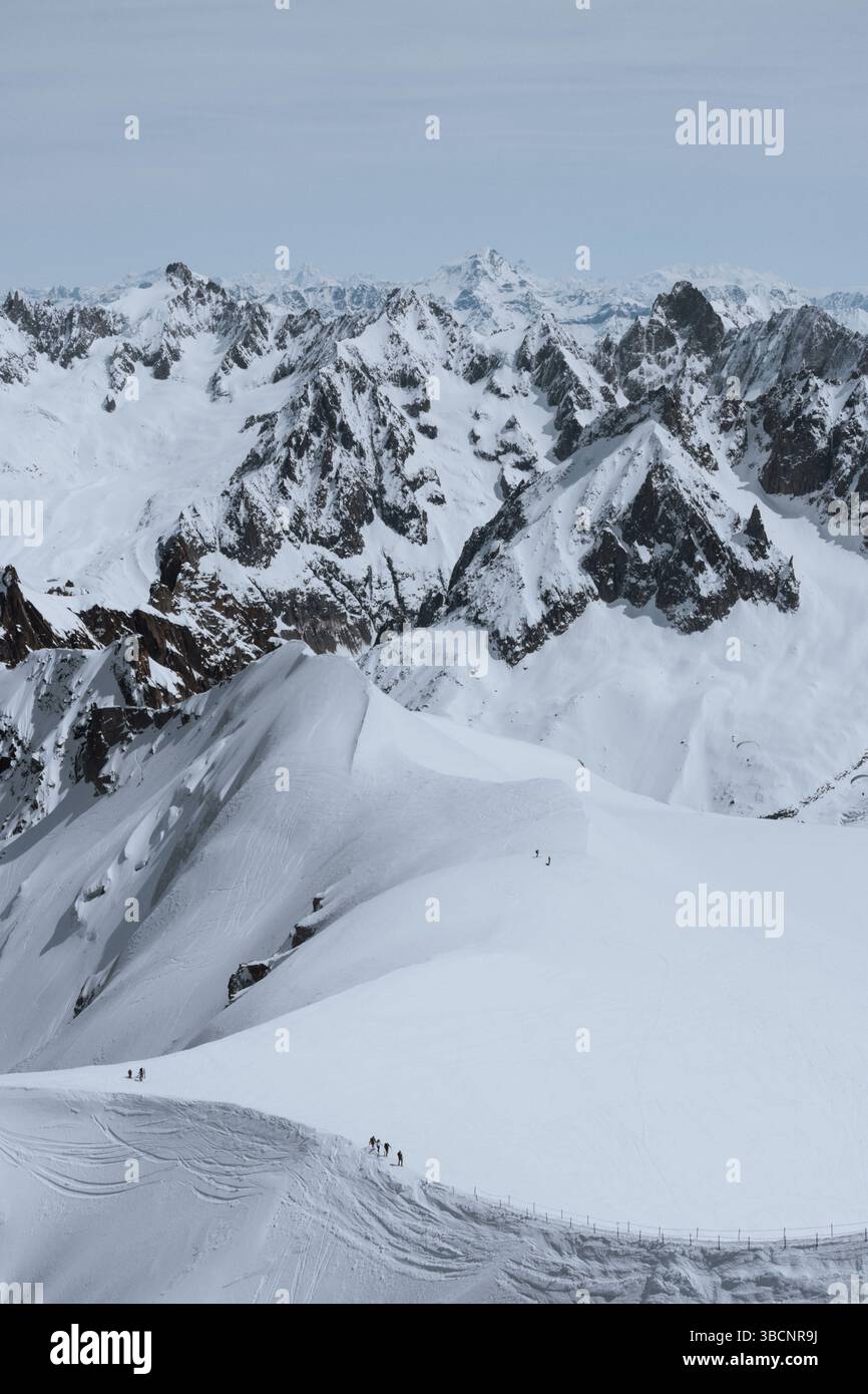 Scialpinisti su una splendida cresta vicino a Aigulle du Midi nel massiccio del Monte bianco nelle alpi francesi sopra Chamonix, con uno scenario montano spettacolare. Foto Stock