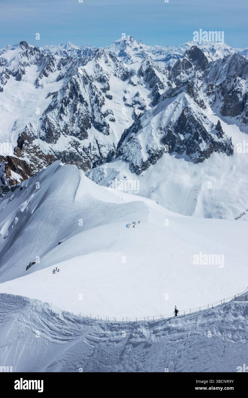 Scialpinisti su una splendida cresta vicino a Aigulle du Midi nel massiccio del Monte bianco nelle alpi francesi sopra Chamonix, con uno scenario montano spettacolare. Foto Stock