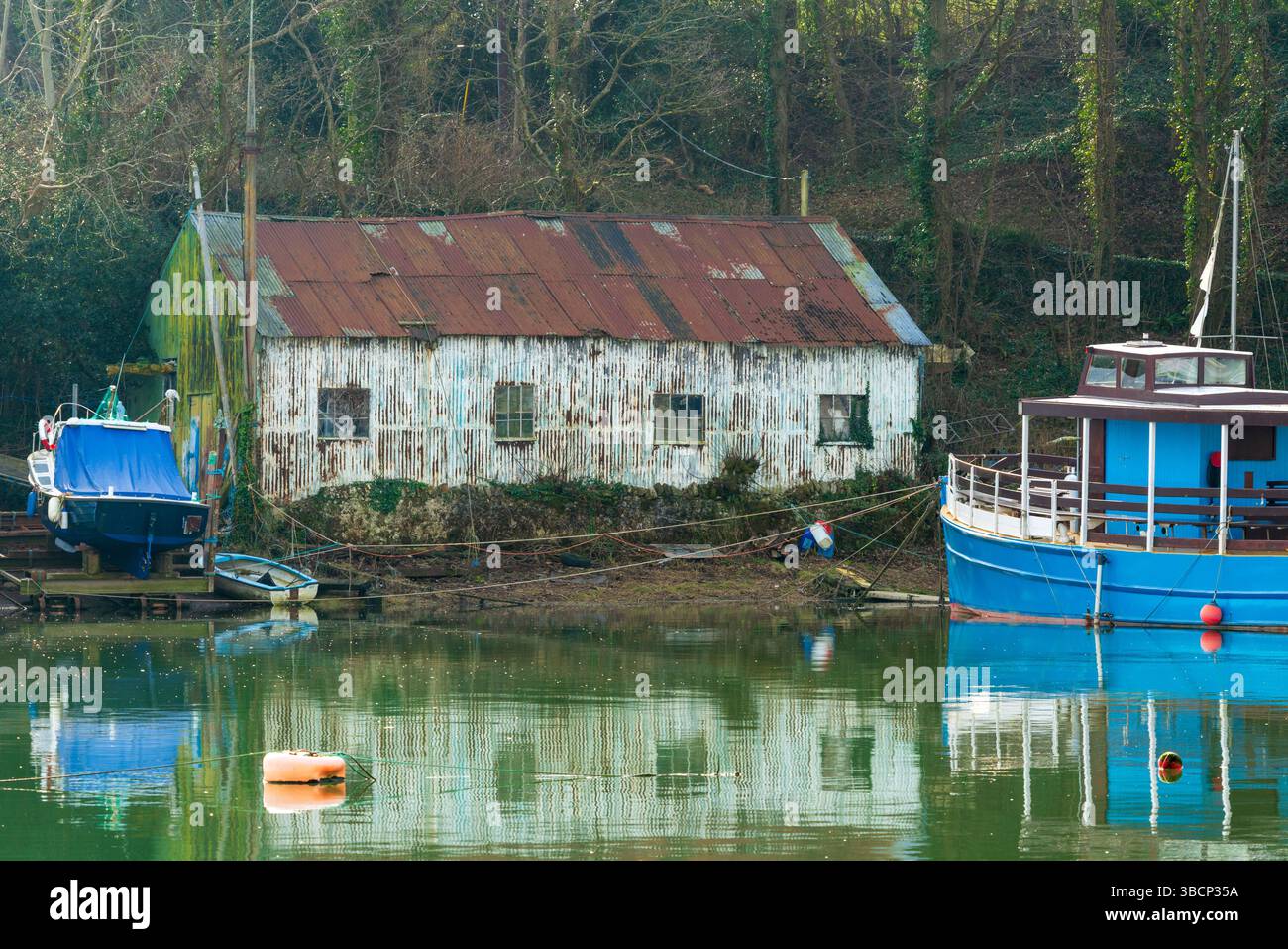 Casa per barche fatiscente sulla riva del fiume Afon Seiont, Caernarfon, Gwynedd, Galles, Regno Unito Foto Stock