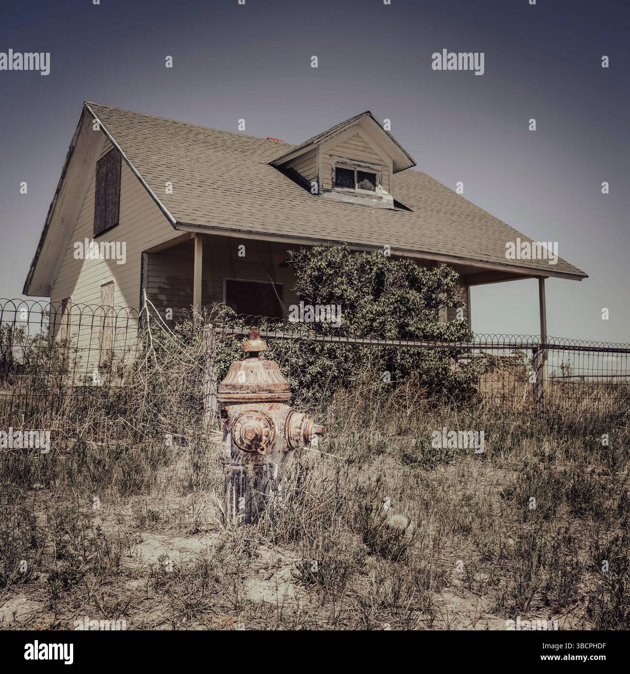 Una casa abbandonata in un piccolo villaggio con un vecchio punto d'acqua del fuoco nelle praterie nazionali di Pawnee, colorado, stati uniti. Foto Stock