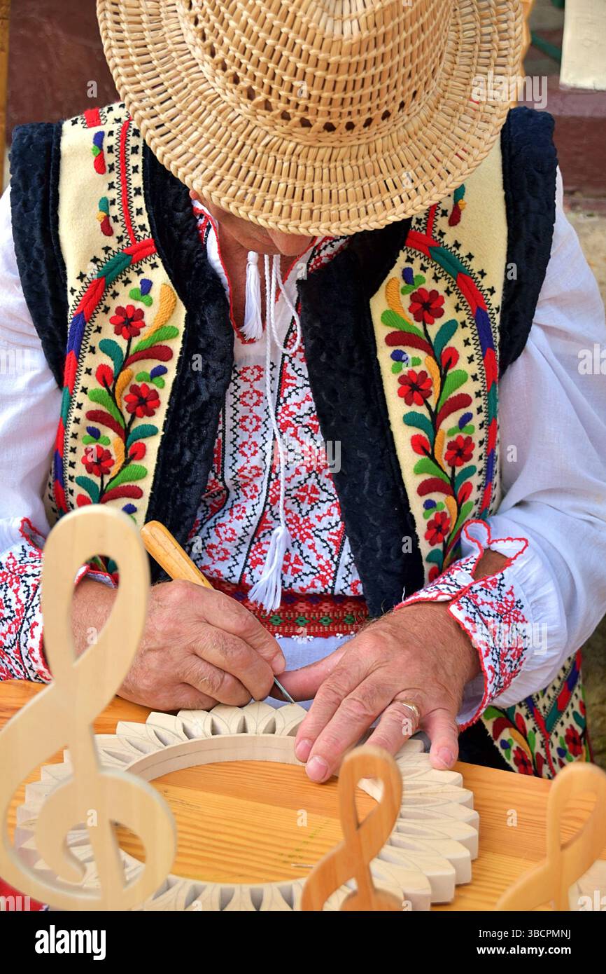 Artigiano del legno tradizionale rumeno al lavoro, in una fiera, a Slanic Moldova Foto Stock