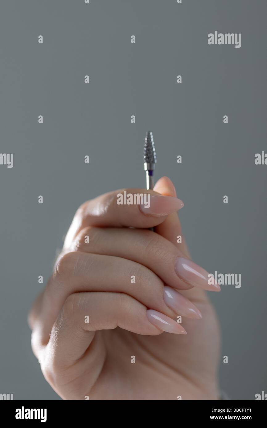 Gli strumenti di manicure sono a portata di mano per lavorare su una bella manicure beige, primo piano di un salone. Foto Stock