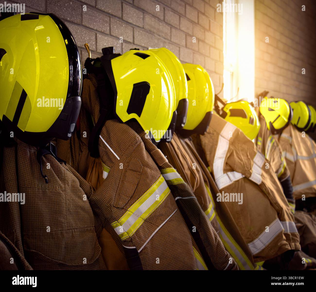 Equipaggiamento della squadra antincendio dei vigili del fuoco, compresi caschi, guanti, giacca e pantaloni dei servizi di emergenza con altri indumenti e attrezzature nella stazione dei vigili del fuoco. Foto Stock