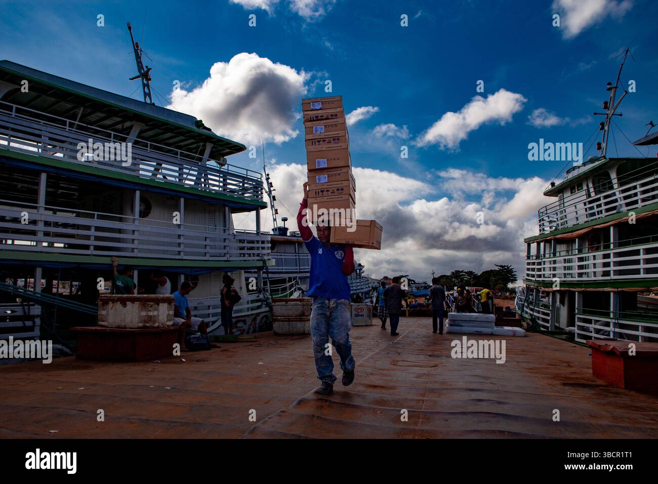 Il lavoratore del porto carica scatole di cosmetici Avon sulle tradizionali barche fluviali amazzoniche al porto di Santarém a Pará, Brasile. Foto Stock