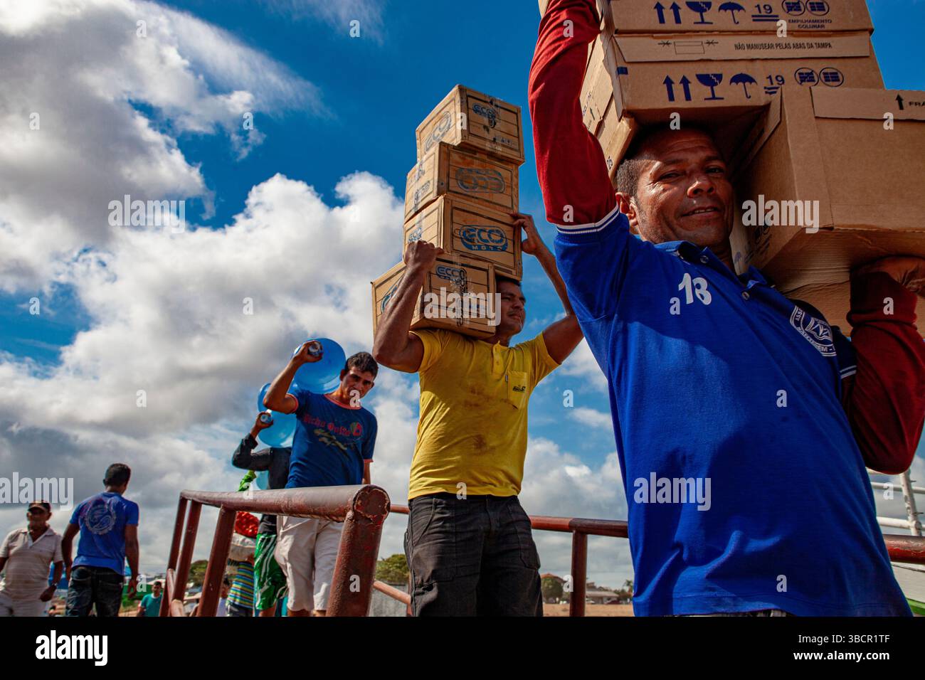 I lavoratori portuali caricano merci diverse sulle tradizionali barche fluviali amazzoniche presso il porto di Santarém a Pará, Brasile. Foto Stock