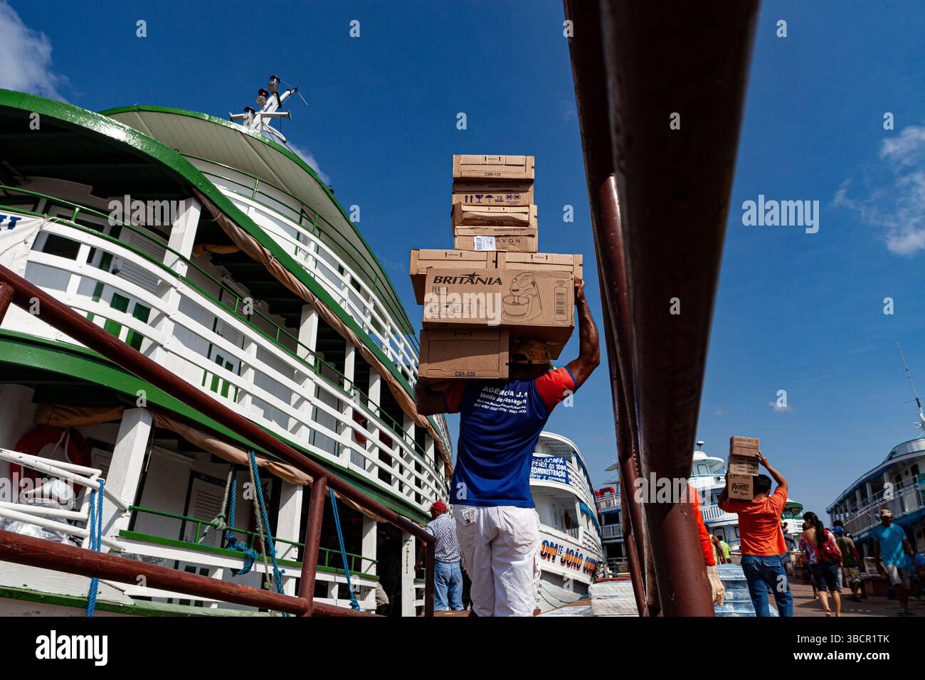 I lavoratori portuali caricano merci diverse sulle tradizionali barche fluviali amazzoniche presso il porto di Santarém a Pará, Brasile. Foto Stock
