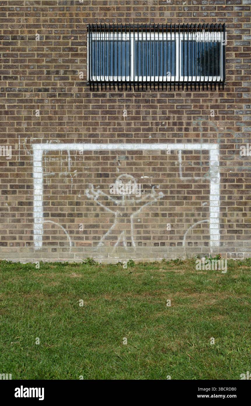 Pali per gol di calcio dipinti di bianco sul lato del muro in un piccolo parco di un villaggio nell'Essex nel Regno Unito Foto Stock