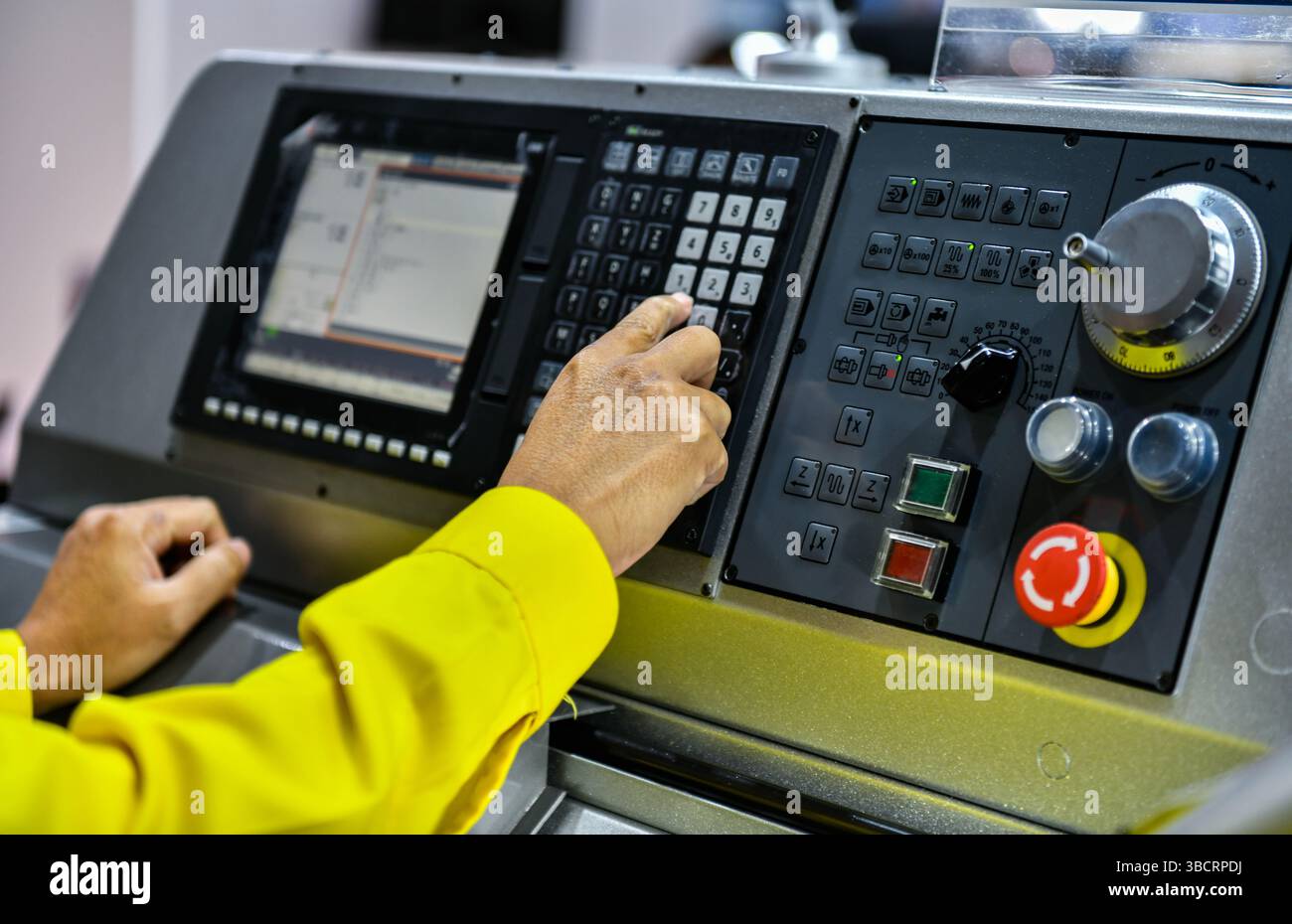 Primo piano la mano dell'operatore della macchina gira sul pannello di controllo della macchina industriale. pulsante del tecnico sul pannello di controllo Foto Stock