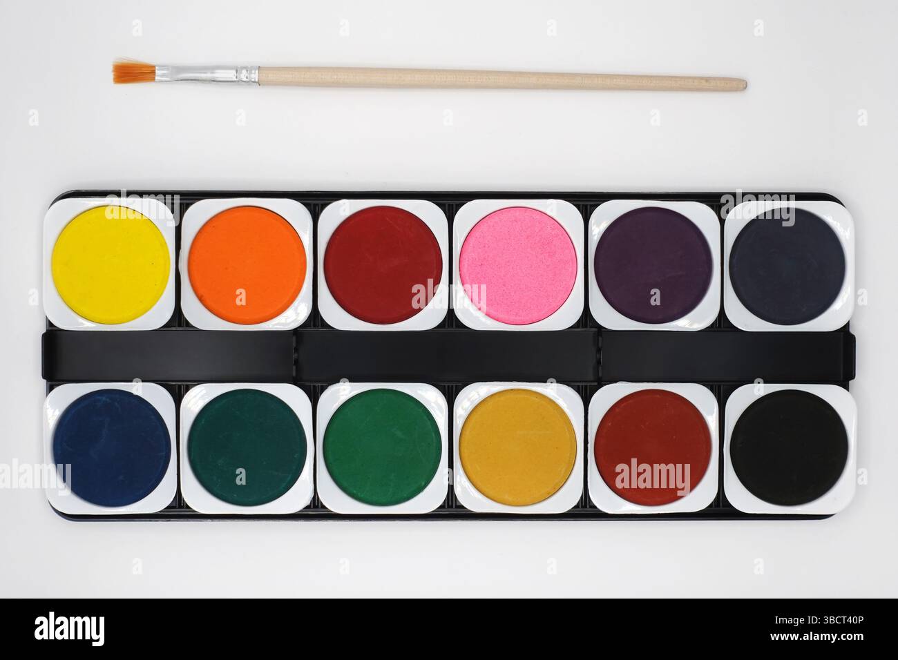 Set di colori per acquerello e pennello su sfondo bianco. Foto Stock