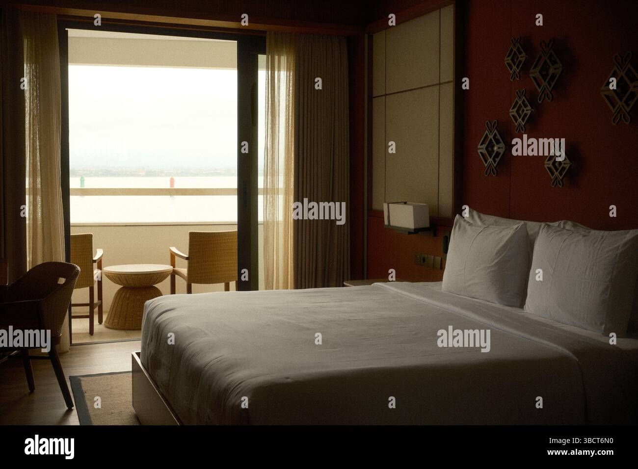 Accogliente camera d'hotel con decor minimalista e un tranquillo balcone con vista sull'oceano Foto Stock