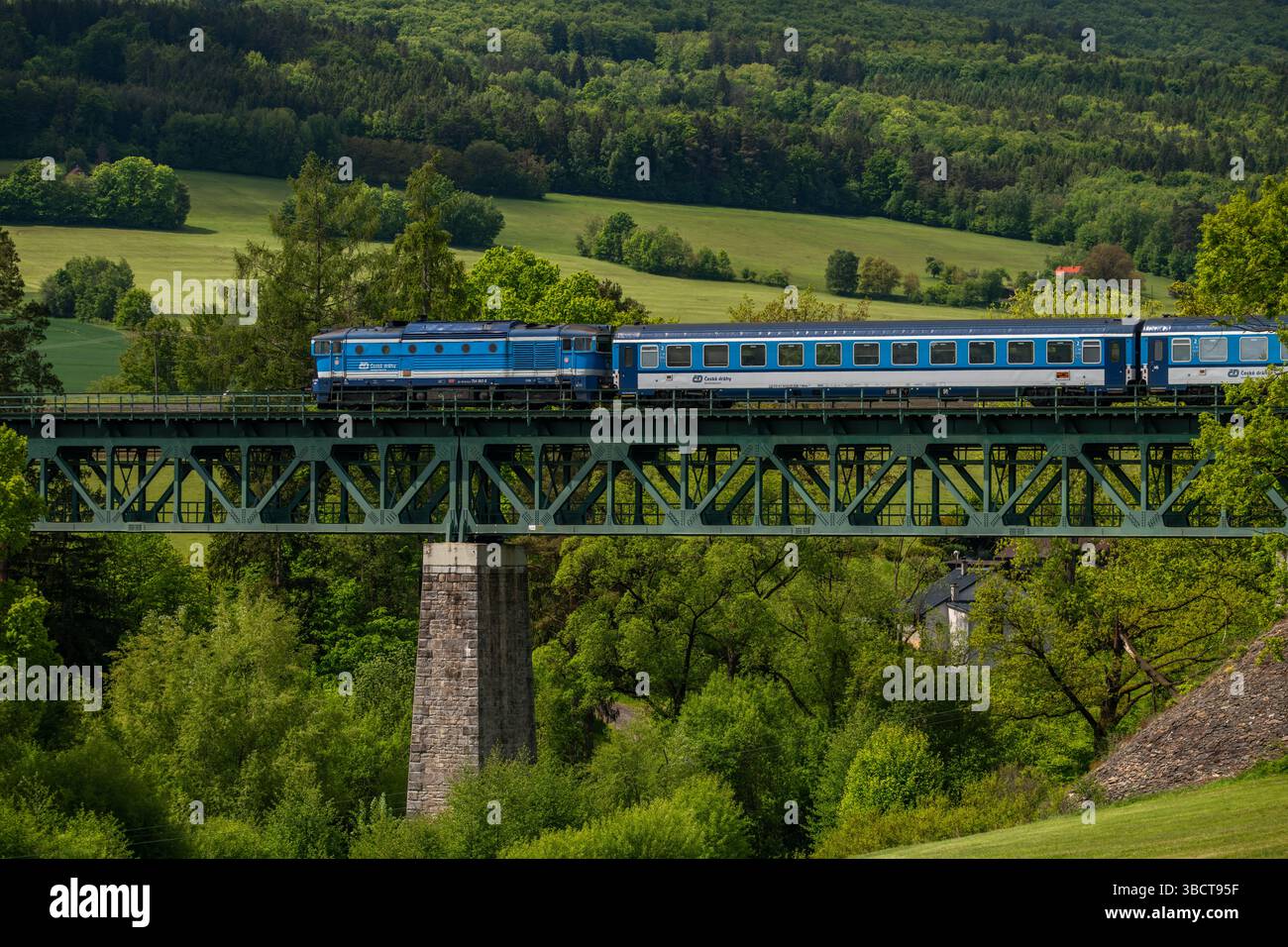 Treno rapido passeggeri blu per Cesky Krumlov vicino al vecchio viadotto Holubov CZ 05 17 2025 Foto Stock