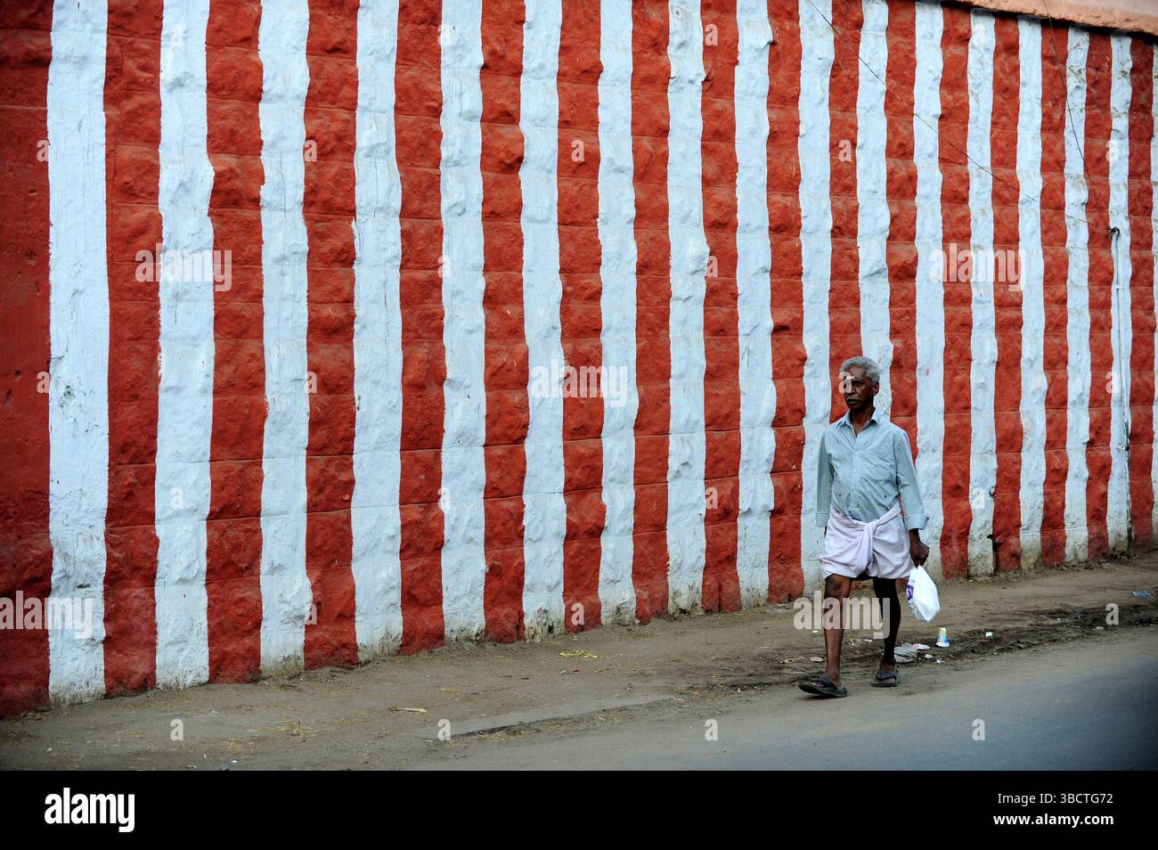 Asie, Inde du Sud, Madurai, Tamil Nadu, homme passant devant le mur d'enceinte d'un Temple/Wall of Temple a Madurai, Tamil Nadu, India meridionale, Asia Foto Stock