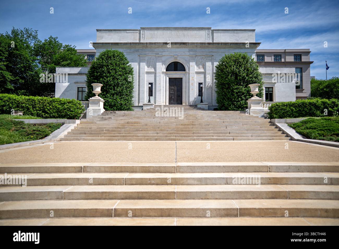 WASHINGTON DC - l'American Pharmacists Association Building si trova in primo piano su Constitution Avenue di fronte al Lincoln Memorial. Progettata dall'architetto John Russell Pope e completata nel 1934, questa struttura neoclassica presenta un monumentale tempio frontale con sei colonne doriche che sostengono un frontone adornato con rilievi scultorei che raffigurano la storia della farmacia. Il quartier generale in marmo bianco e pietra calcarea funge sia da spazio per uffici per la prima società professionale di farmacisti della nazione sia da punto di riferimento architettonico lungo il confine nord-occidentale del National Mall. Foto Stock