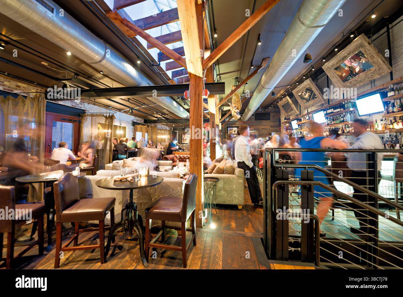 Virtue Feed and Grain Restaurant Interior Alexandria Virginia // ALEXANDRIA, Virginia - il ristorante Virtue Feed and Grain occupa un magazzino storico nel cuore della città vecchia di Alexandria. L'edificio, originariamente costruito negli anni '1800 come negozio di alimenti e cereali, è stato meticolosamente restaurato e convertito in un popolare ristorante. Situato vicino al lungomare del fiume Potomac, il ristorante presenta pareti in mattoni a vista, travi in legno e decorazioni di ispirazione industriale che rendono omaggio al suo passato utilitaristico. Foto Stock