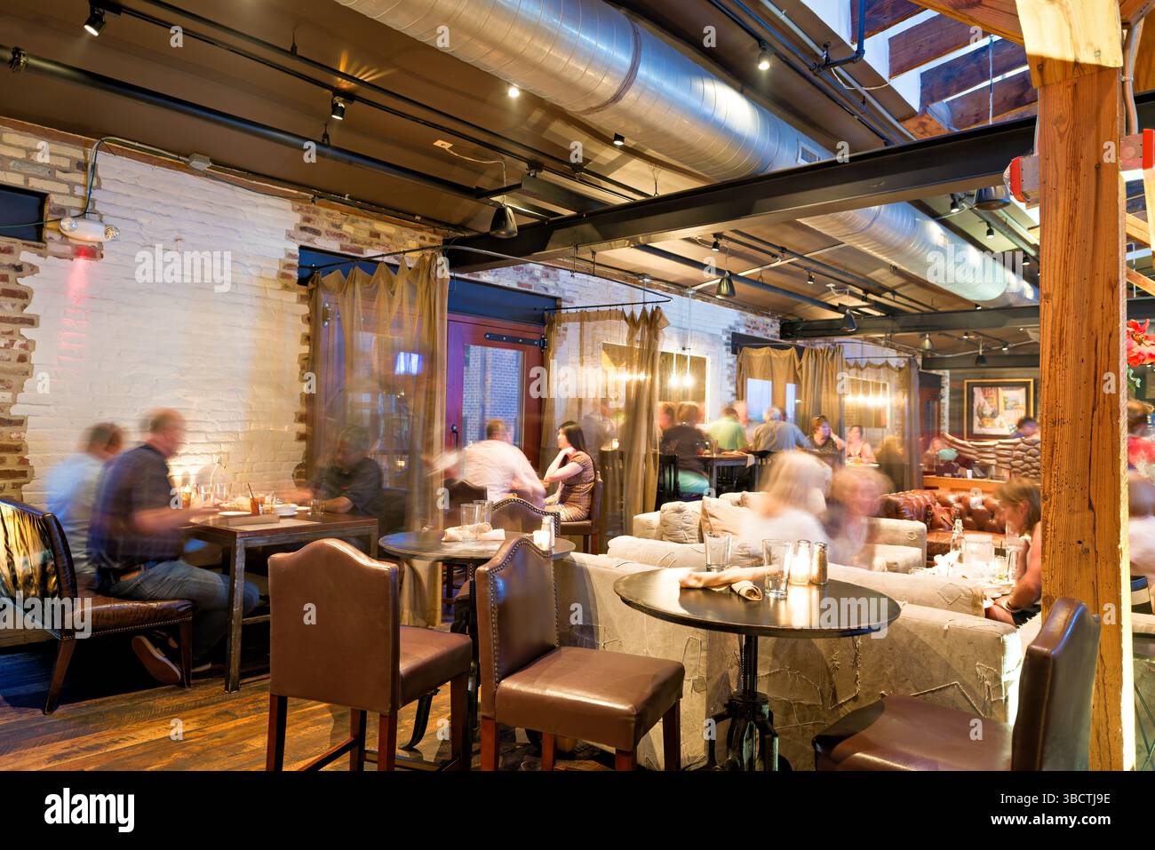 Virtue Feed and Grain Restaurant Interior Alexandria Virginia // ALEXANDRIA, Virginia - il ristorante Virtue Feed and Grain occupa un magazzino storico nel cuore della città vecchia di Alexandria. L'edificio, originariamente costruito negli anni '1800 come negozio di alimenti e cereali, è stato meticolosamente restaurato e convertito in un popolare ristorante. Situato vicino al lungomare del fiume Potomac, il ristorante presenta pareti in mattoni a vista, travi in legno e decorazioni di ispirazione industriale che rendono omaggio al suo passato utilitaristico. Foto Stock