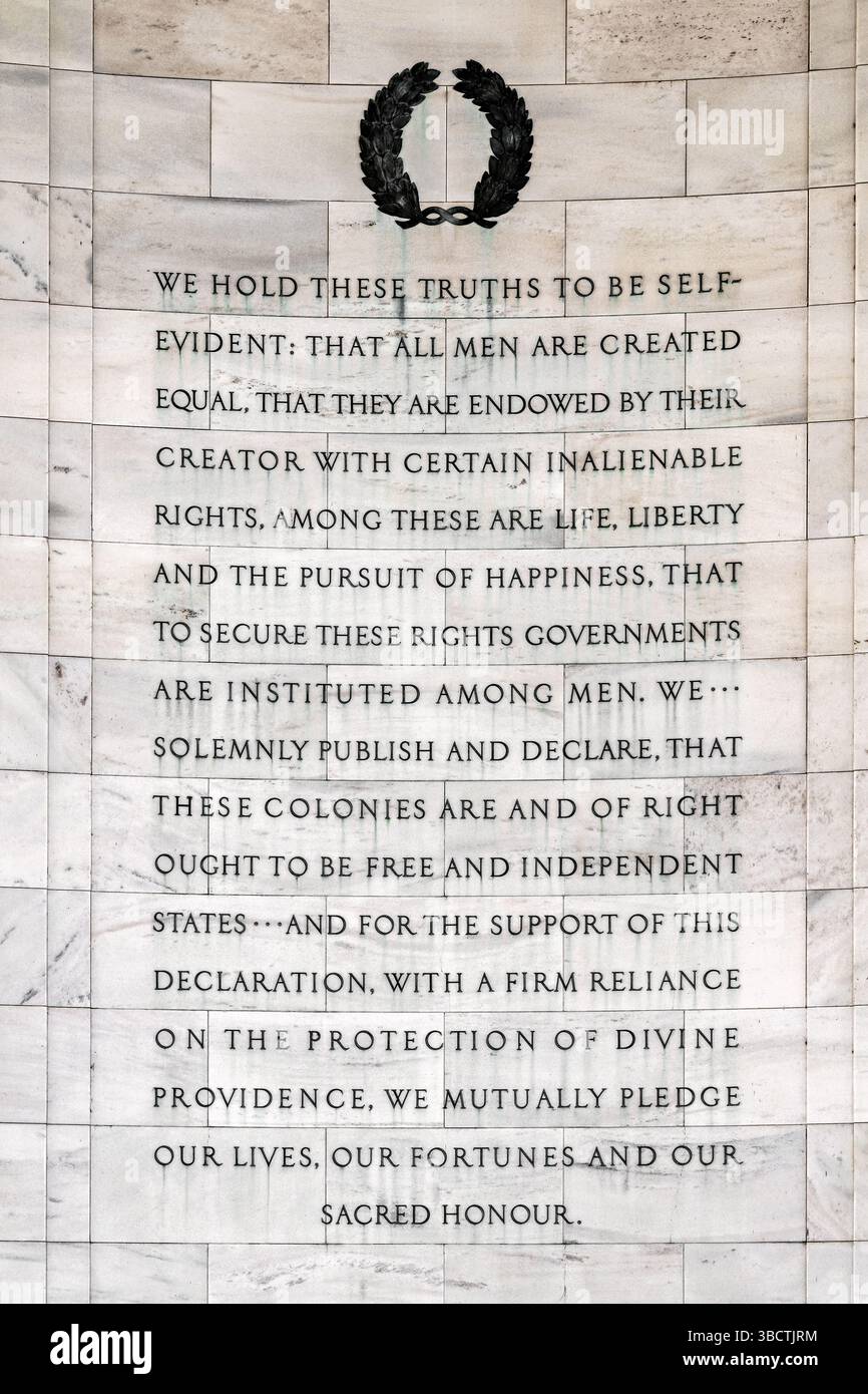 Dichiarazione di indipendenza iscrizione sul muro interno del Jefferson Memorial a Washington DC | WASHINGTON D.C., Stati Uniti - Una visione più ravvicinata della dichiarazione di indipendenza estratto inciso sul muro interno curvo del Jefferson Memorial si estende oltre il preambolo fino alla promessa finale del documento di "vite", "fortune" e "onore sacro". Il testo condensato, alterato dall'originale di Jefferson del 1776 per lo spazio, fu scolpito in pannelli di marmo sotto la cupola del memoriale, completato dopo la morte dell'architetto John Russell Pope nel 1937 dai suoi partner otto R. Eggers e Daniel P. Higgins. Foto Stock