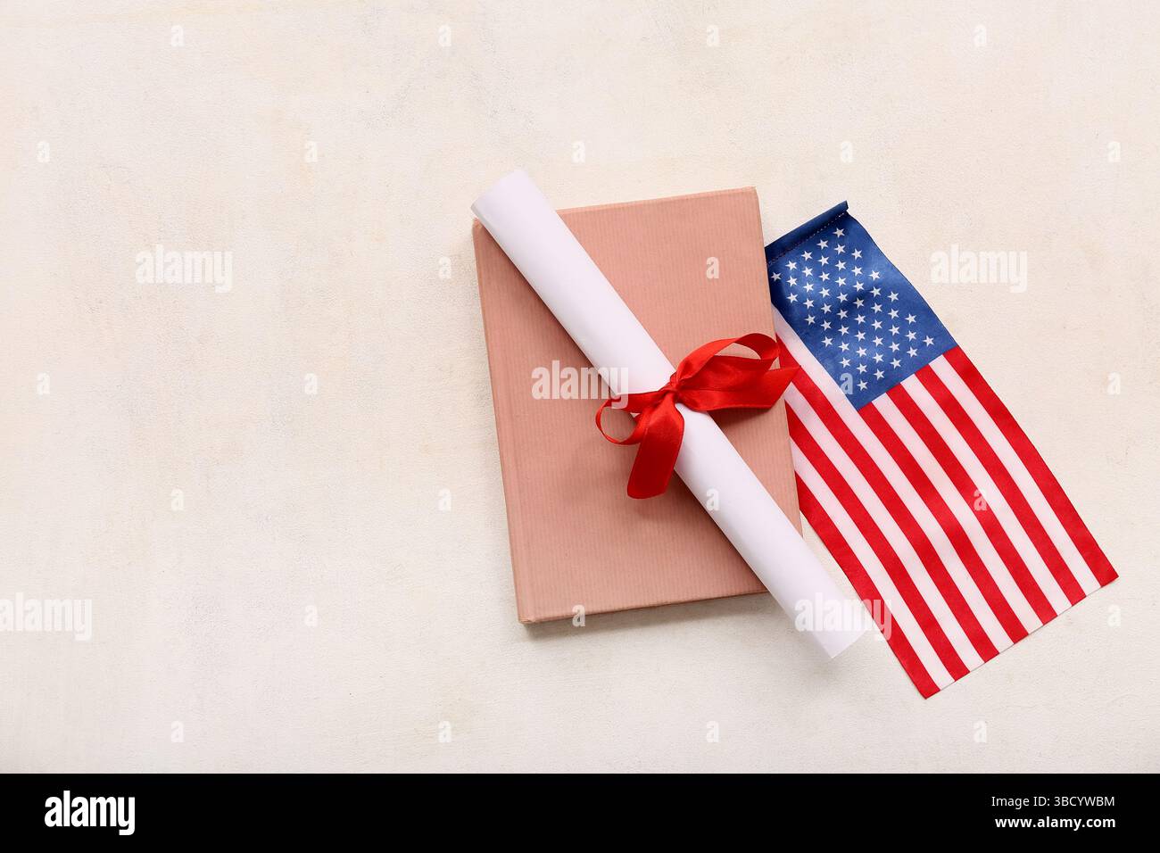 Diploma con nastro rosso, bandiera USA e libro su sfondo grunge bianco Foto Stock