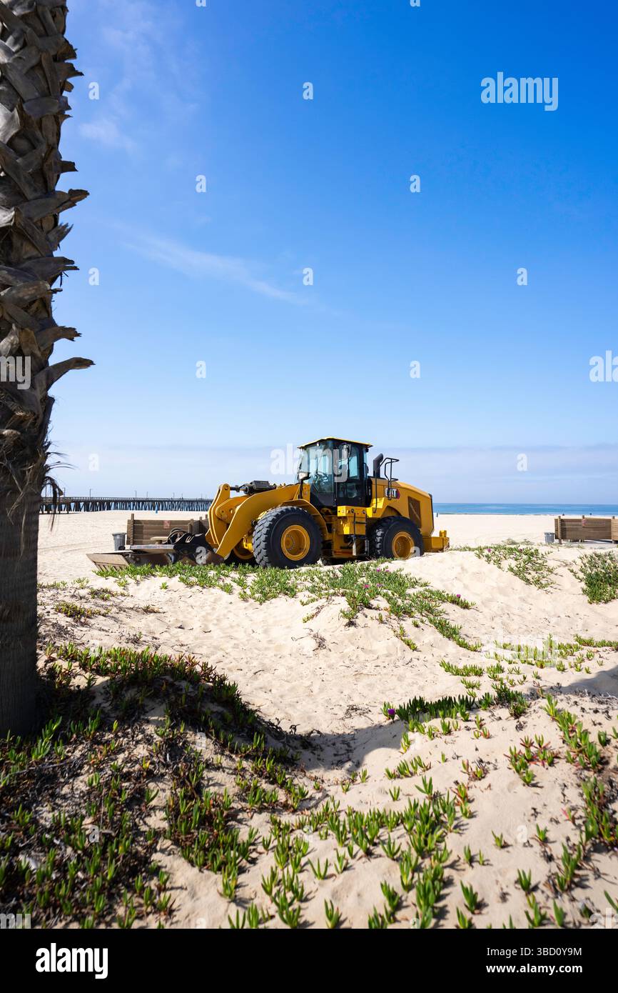 Bulldozer trattore giallo sulla spiaggia Foto Stock