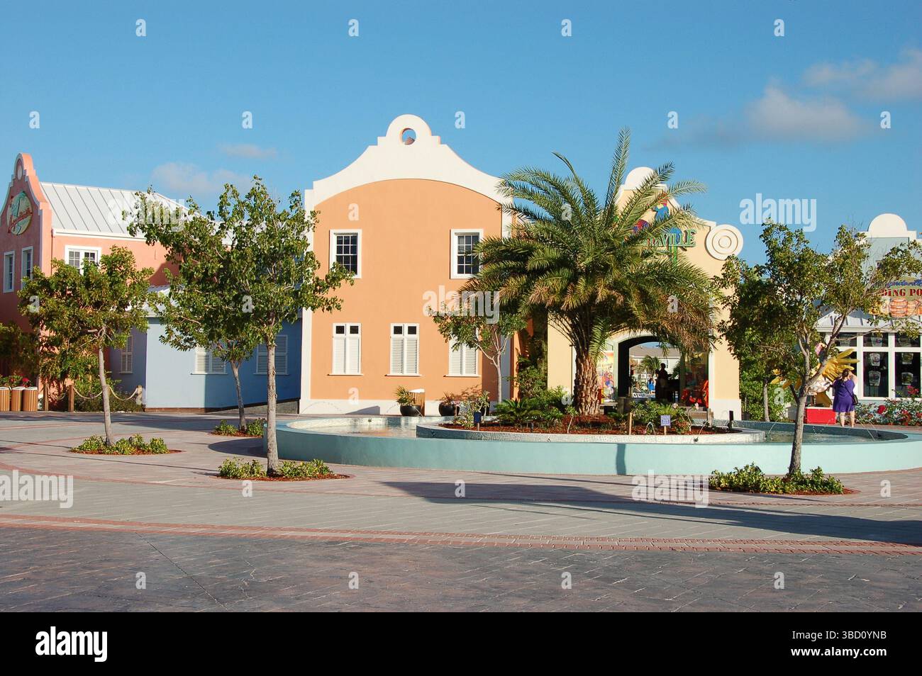 Colorati edifici in stile coloniale e un cortile paesaggistico con palme e una fontana presso il porto crocieristico di Grand Turk, Turks e Caicos Foto Stock