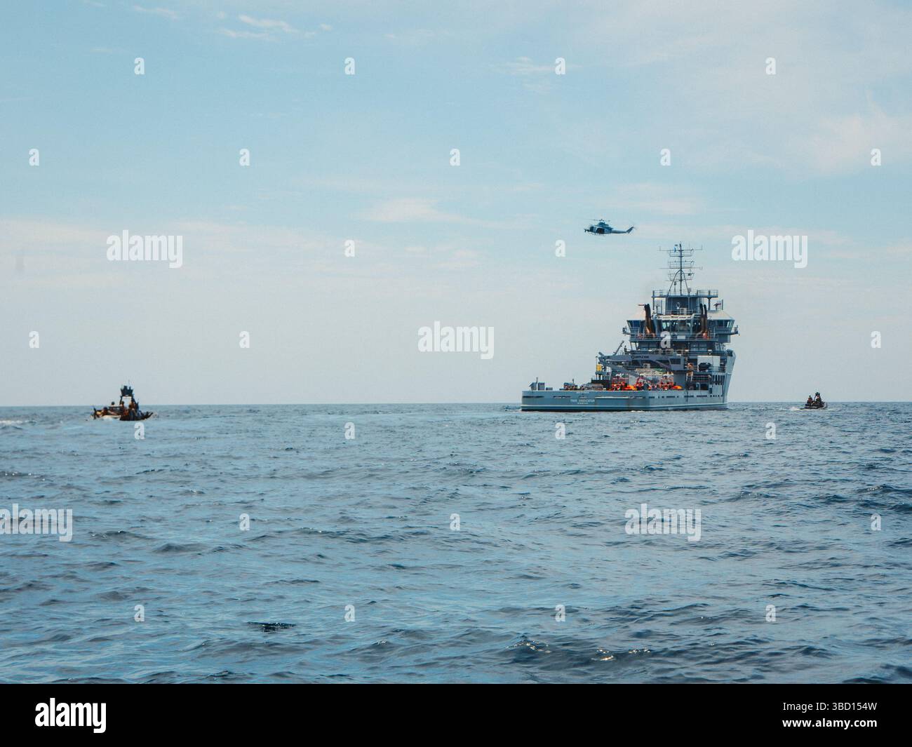 US Marines with Maritime Special Purpose Force, 22nd Marine Expeditionary Unit, forniscono sicurezza dalle imbarcazioni gonfiabili a scafo rigido potenziato e da un UH-1Y Venom con Marine Medium Tiltrotor Squadron 263 (rinforzato) mentre conducono operazioni di intercettazione marittima a bordo della nave di supporto per l'addestramento USNS Vindicator (TSV5) della US Navy a sostegno dell'Iwo Jima Amphibious Ready Group Marine Expeditionary Unit Expeditionary Unit Expeditionary Unit Exercise (ARGMEUEX) durante il 18 maggio 2025. Durante ARGMEUEX, il 22° MEU, a bordo DELLA IWO ARG Shipping, conduce vari compiti essenziali della missione che migliorano il readi operativo Foto Stock
