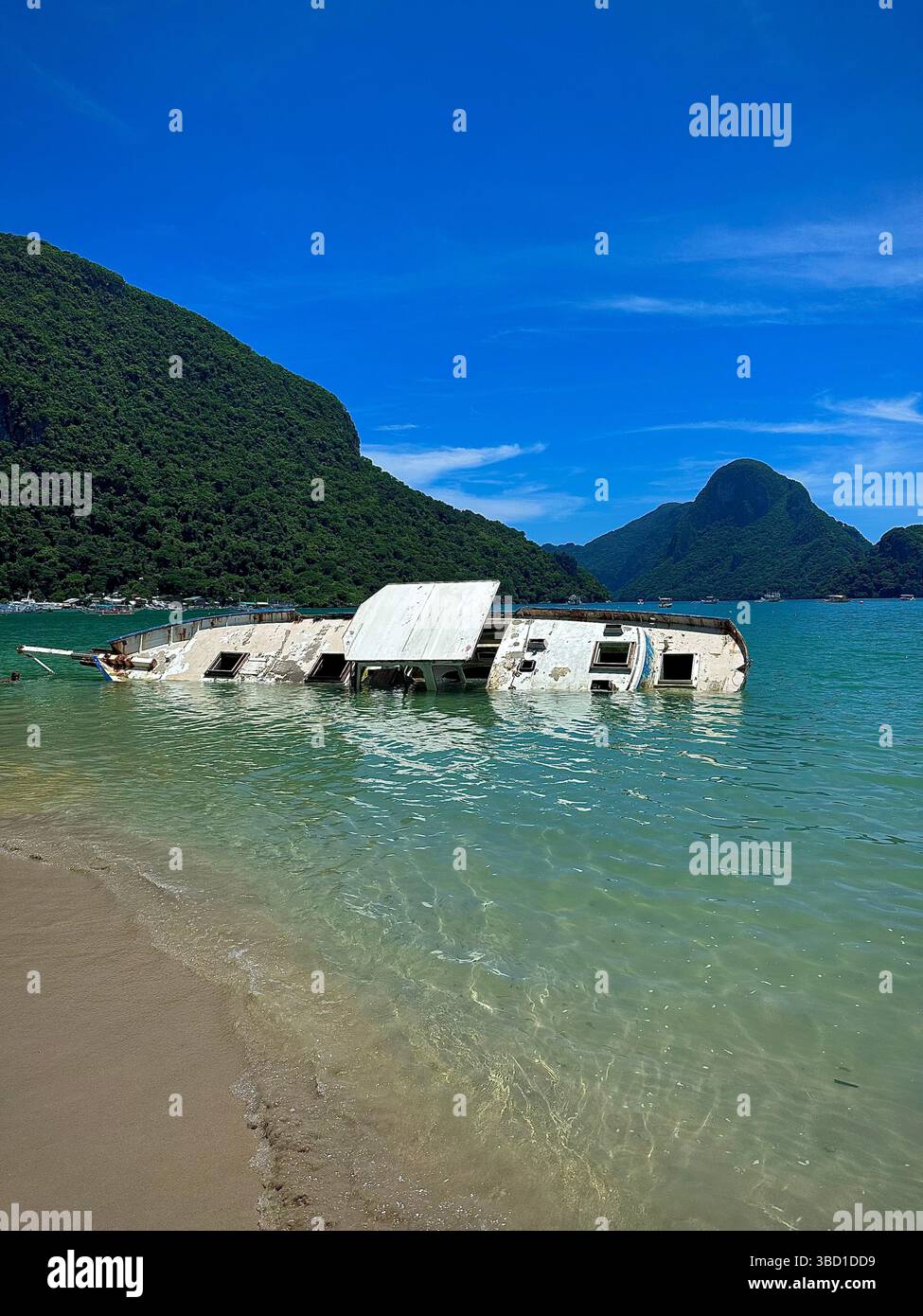 Il relitto abbandonato si trova in acque turchesi poco profonde vicino a un'isola tropicale, ideale per viaggi, avventure e storie. - Immagine stock catturata con smartphone