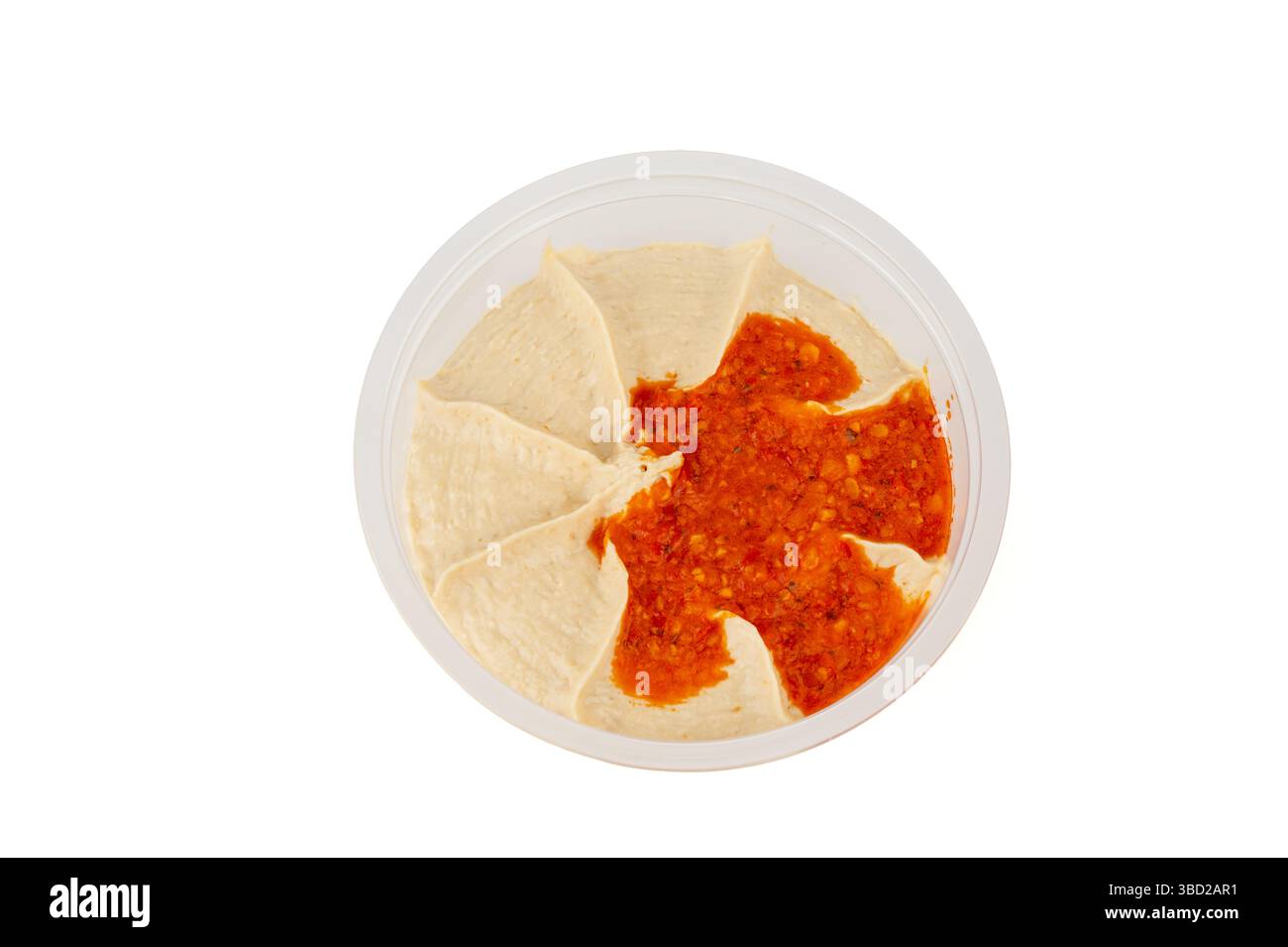 L'hummus dip è fotografato dall'alto. Mostrando la distribuzione uniforme della pasta di peperoncino rosso sull'hummus cremoso. Foto Stock