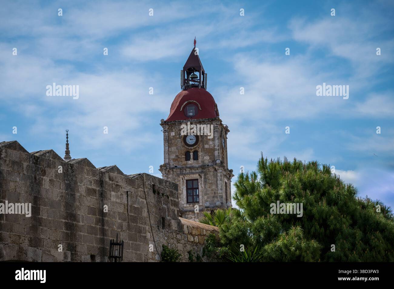 Foto di una torre dell'orologio nella città vecchia di Rodi contro un cielo blu Foto Stock