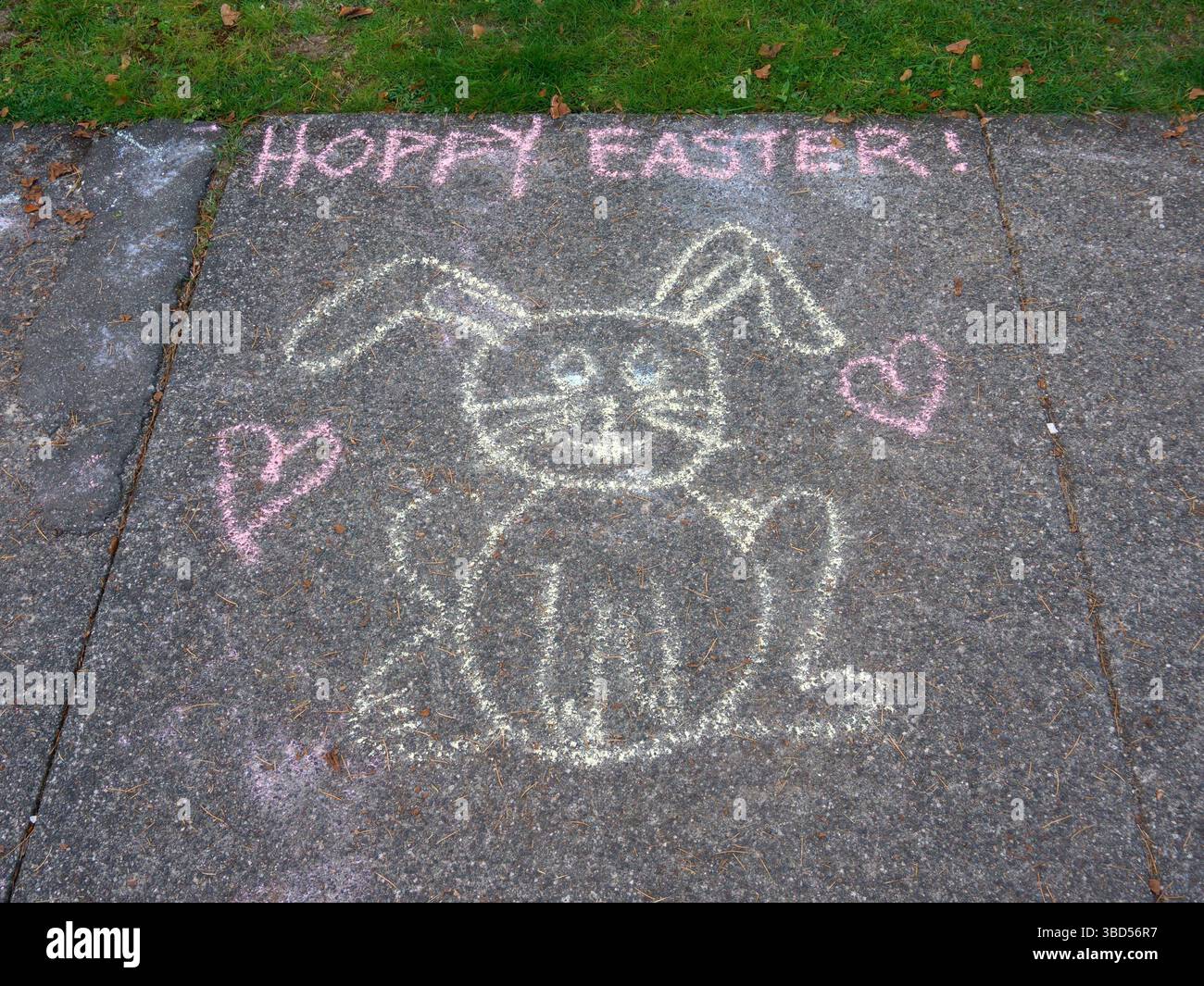 Disegno in gesso per bambini del coniglietto di Pasqua felice (Hoppy Easter) sul marciapiede Foto Stock