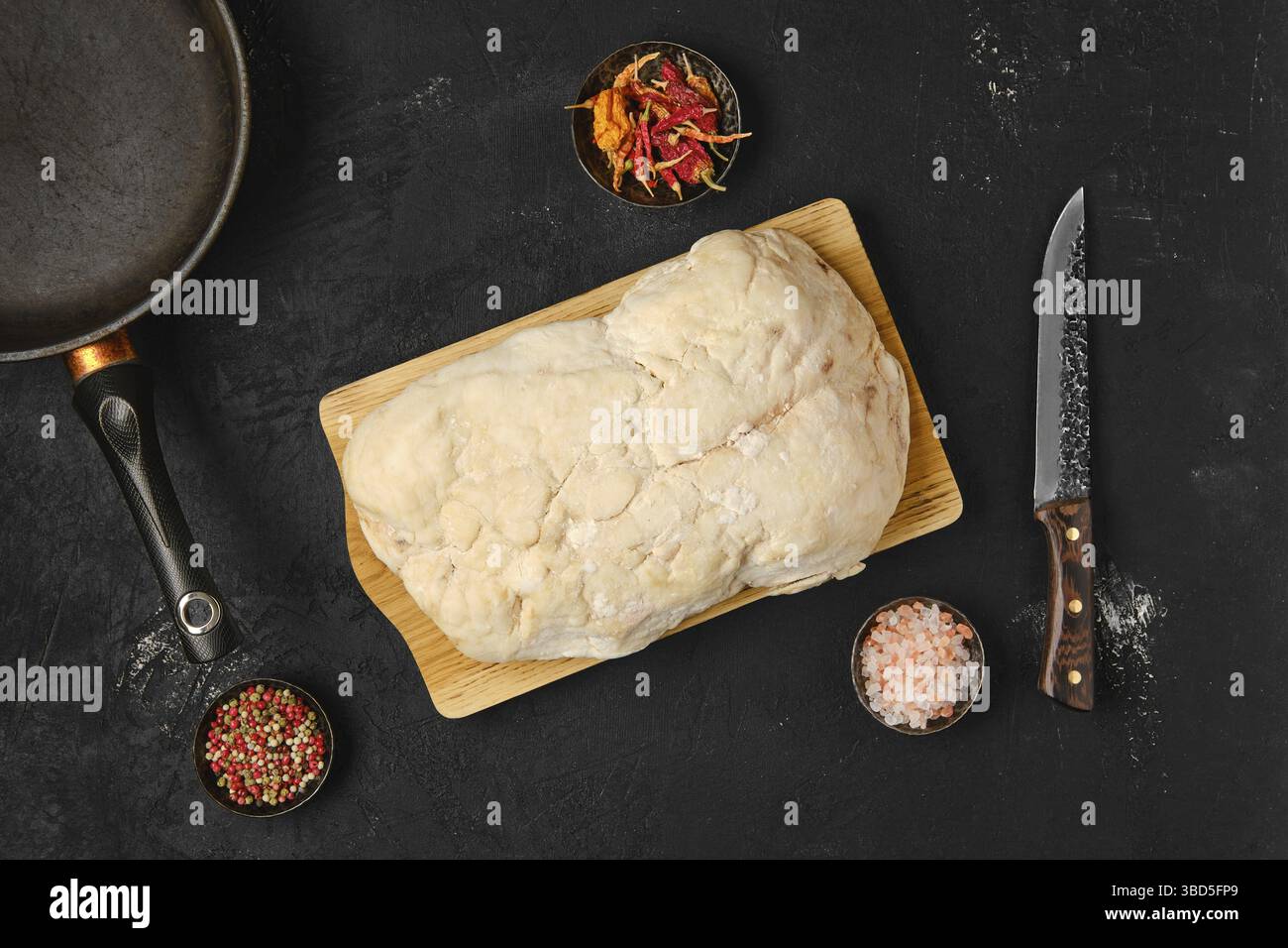 Vista dall'alto della coda di grasso di agnello sul tavolo da cucina con sale e pepe Foto Stock