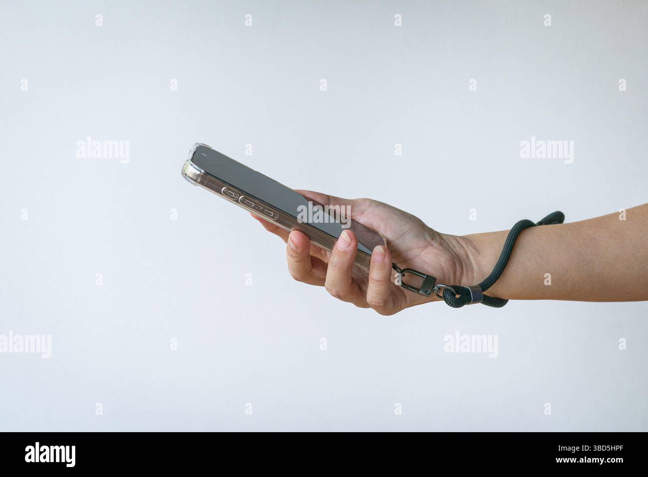 Donna che regge un telefono con un cinturino da polso. Vista ravvicinata. Isolato su sfondo bianco. Foto Stock