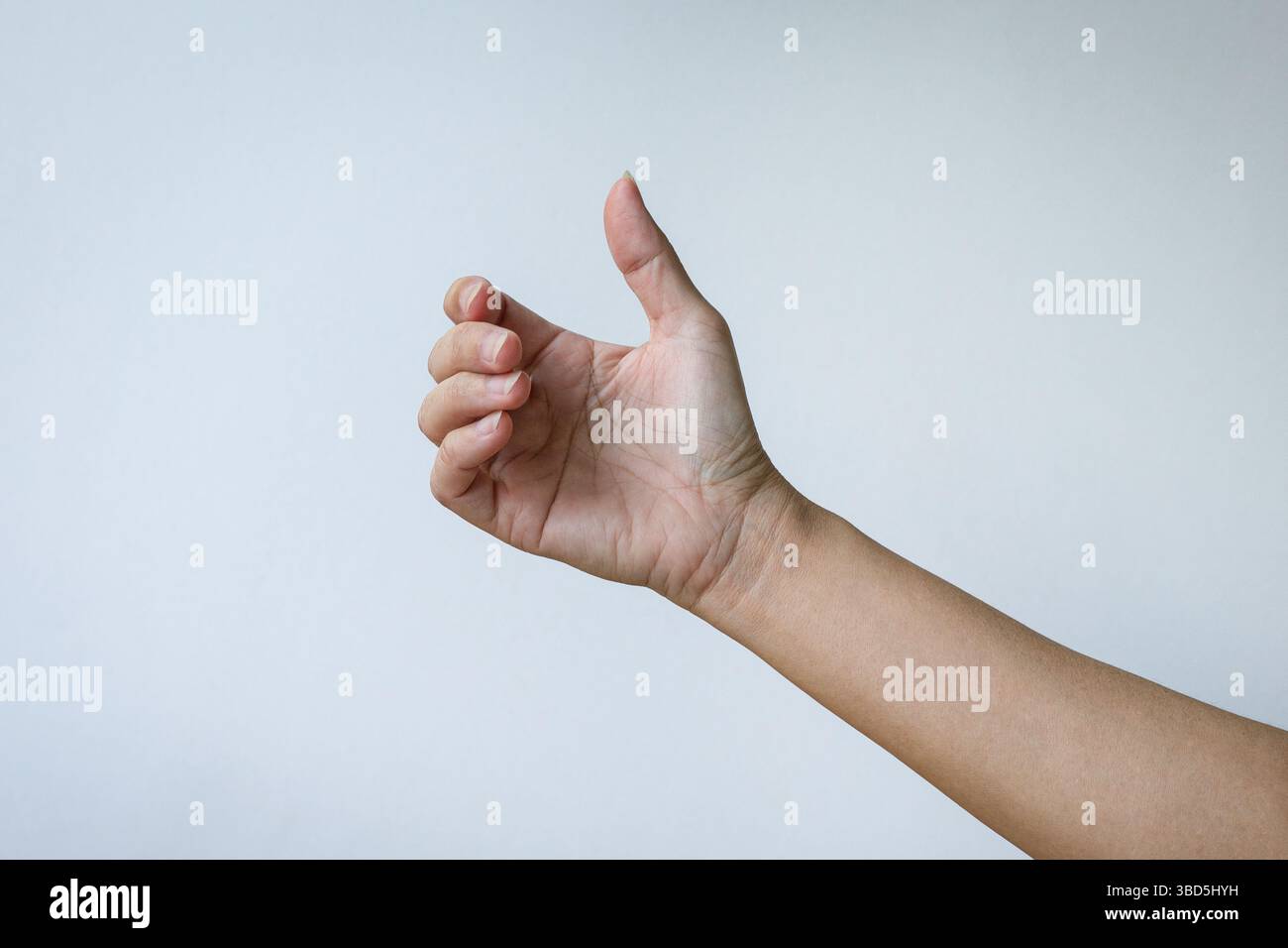 Mano di una donna che tiene un telefono invisibile o un gesto di un oggetto. Isolato su sfondo bianco. Foto Stock