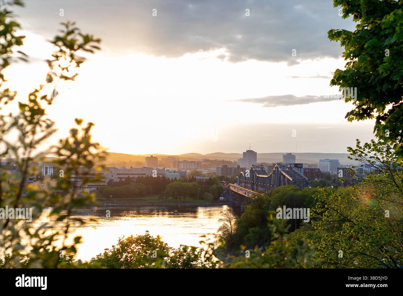 Ottawa, Canada - 16 maggio 2024: Fiume Ottawa al tramonto. Vista sul ponte di Alexandra e sulla città di Gatineau. Foto Stock